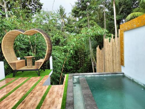 a backyard with a pool and a chair and a heart at Baruna Sari Villa yoga and reatret view jungle in Ubud