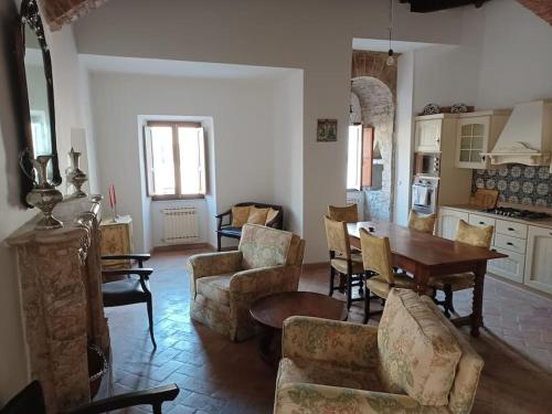een woonkamer met een tafel en stoelen bij Charming apartment in medieval tower in Spoleto