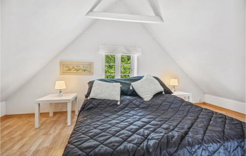 a bedroom with a bed and two tables and a window at 2 Bedroom Pet Friendly Home In rskbing in Ærøskøbing