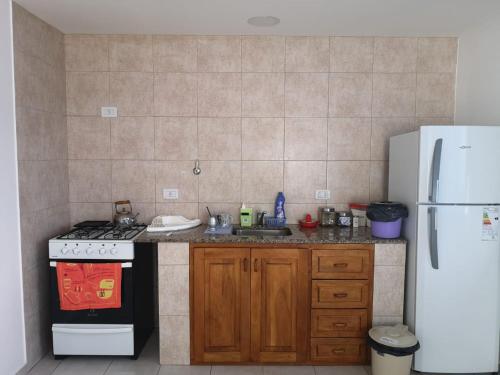 a kitchen with a stove and a refrigerator at Departamento amplio y luminoso in Esquel