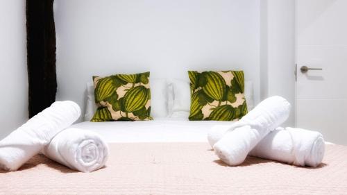 a bed with three rolled towels on it at Bilbao Ronda apartamento con balcón Casco Viejo in Bilbao