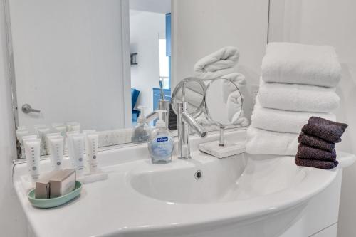 a white bathroom sink with towels and a mirror at Highest floor Icon W Brickell Location in Miami