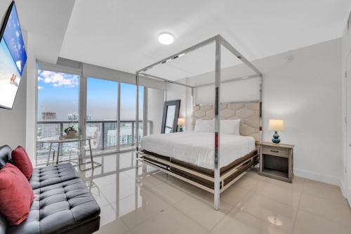 a bedroom with a canopy bed and a couch at Highest floor Icon W Brickell Location in Miami