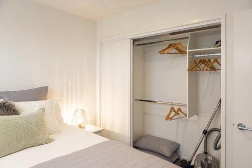- une chambre avec un lit et un placard avec des chaussures dans l'établissement Hagley Park Views, à Christchurch