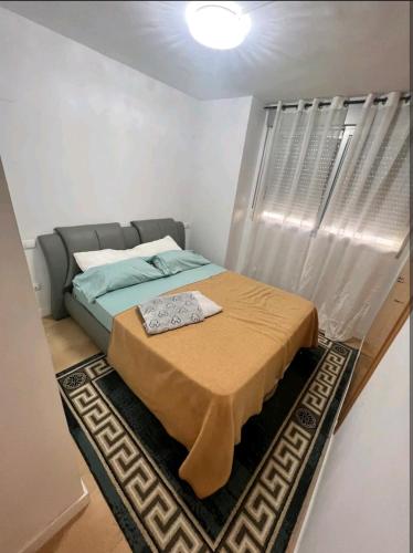 a bedroom with a bed with a blanket on it at apartment in Valencia