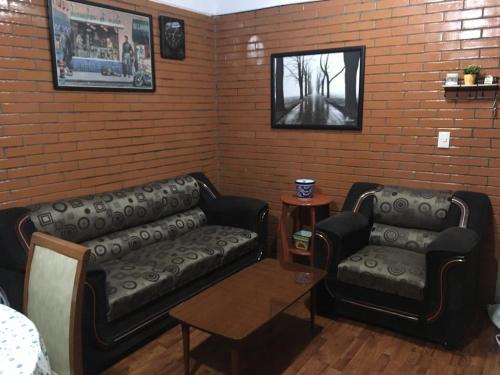 a living room with two leather couches and a table at Vista Espectacular in Mexico City