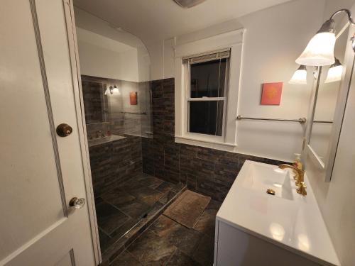uma casa de banho com um lavatório e um chuveiro em And.N Bed & Breakfast em Gray