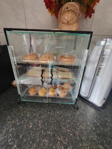 a display case full of donuts on a counter at Econolodge in Andalusia