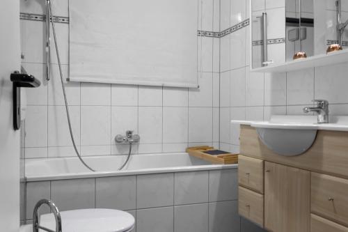 a bathroom with a bath tub and a sink at Gemütliches Apartment in Köln - SmartTV - Küche in Cologne