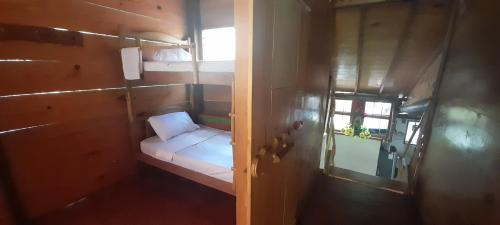 Cette petite chambre comprend un petit lit et une fenêtre. dans l'établissement Cabaña Altos de San Carlos, à Santa Marta