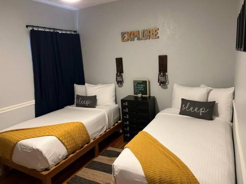 a bedroom with two beds and a sign that reads excellence at Split level 4blocks from rt 66-hot tub - EV charger - firepit in Williams