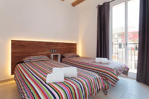 two twin beds in a room with a large window at Radas in Barcelona