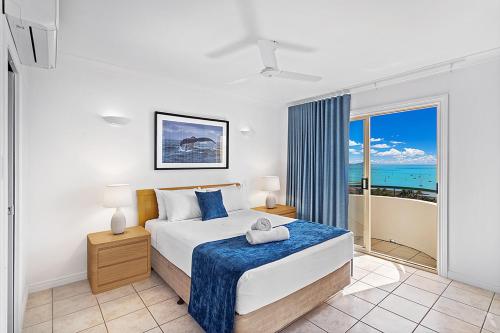 a bedroom with a large bed with a view of the ocean at Airlie Hasta Manana in Airlie Beach