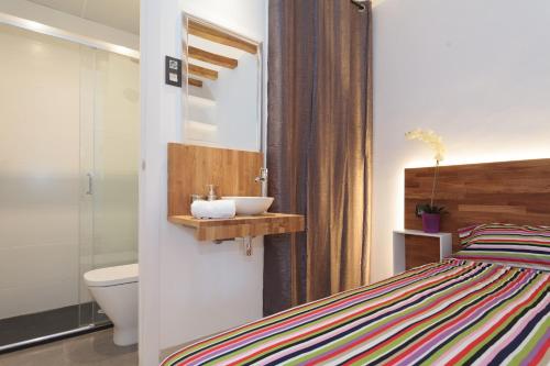 a bathroom with a bed and a sink and a toilet at Radas in Barcelona