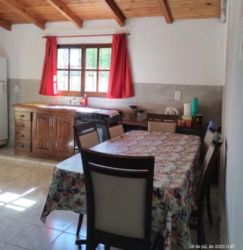 a dining room with a table and a kitchen at Casa para 6 con cochera-Maragus in Posadas