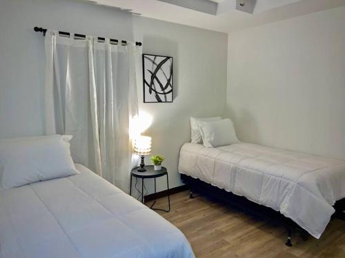 ein Schlafzimmer mit zwei Betten und einem Tisch mit Lampe in der Unterkunft Chic & Cozy 2 bedroom - 1 bathroom - RATED BEST in Eagle Pass