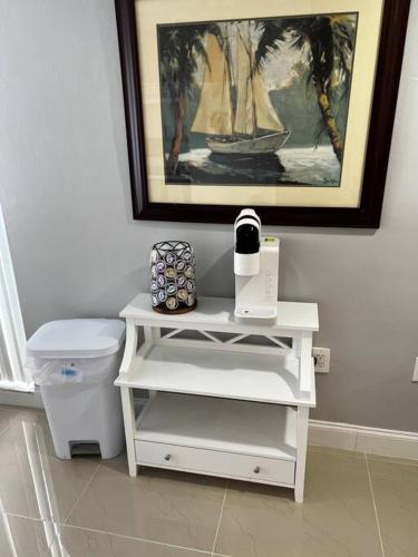 a bathroom with a white table next to a trash can at Comfy 2 bedroom apartment in Port Richey