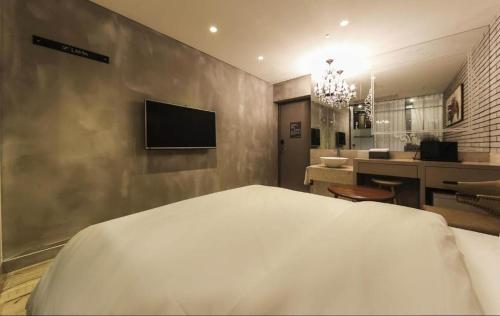 a bedroom with a bed and a television on a wall at Hotel Lassa in Seoul