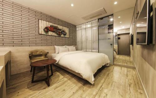 a bedroom with a large bed and a table and a kitchen at Hotel Lassa in Seoul
