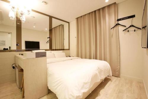 a bedroom with a large bed and a mirror at Hotel Lassa in Seoul