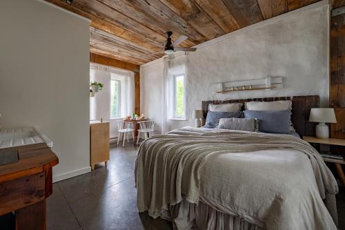 um quarto com uma cama grande e um tecto em madeira em Owl's Nest Suites em Carrying Place