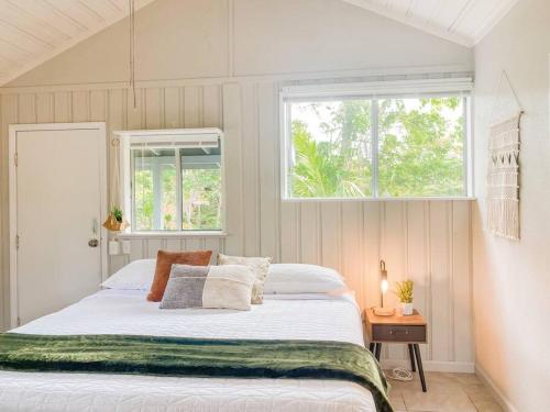 a bedroom with a white bed with a window at Monstera Bungalow, Spacious, King Bed, Big Kitchen in Keaau