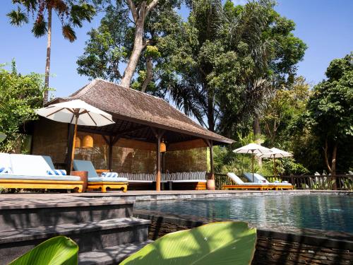 - une piscine avec des chaises longues et des parasols à côté d'un complexe dans l'établissement Villa Simona Oasis, à Canggu