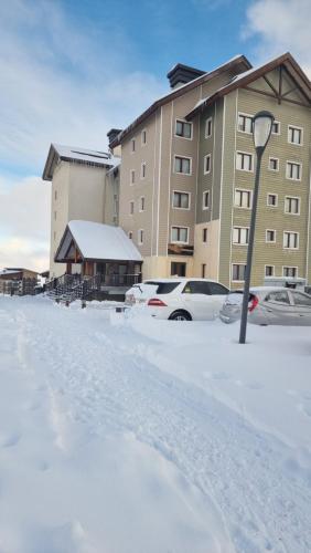 un aparcamiento cubierto de nieve frente a un edificio en Departamento Valle Nevado, Ski in - Ski out en Santiago