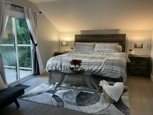 a bedroom with a large bed and a table at Sunsets At The Oasis in Napanee