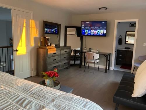 Un dormitorio con una cama y una sala de estar con una mesa. en Sunsets At The Oasis, en Napanee