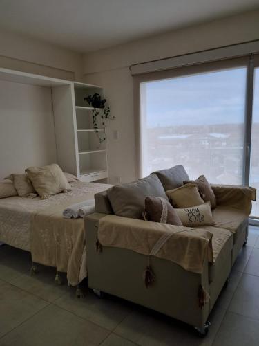 ein Schlafzimmer mit einem Bett und einem großen Fenster in der Unterkunft Bella Vista in Cipolletti