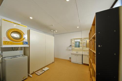 a room with a kitchen with white cabinets and a refrigerator at 芙蓉山居煙霞ー元富士の屋旅館ー in Fujikawaguchiko