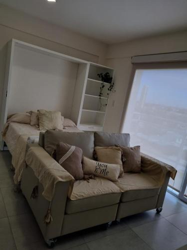 a couch in a room with a large window at Bella Vista in Cipolletti
