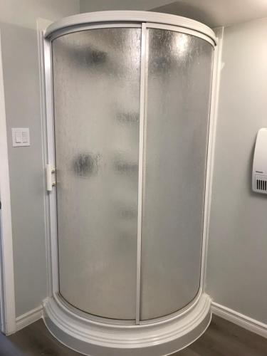 eine Dusche mit Glastür in einem Zimmer in der Unterkunft A Bright Specious 1 Bedroom Unit in the Basement in Ottawa