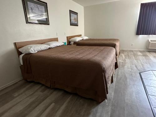 2 Betten in einem Hotelzimmer mit Holzböden in der Unterkunft Jolly Roger Hotel in Los Angeles