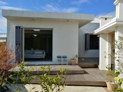 a house with two chairs on a wooden deck at A shell in Jeju in Seogwipo