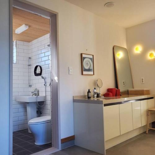 a bathroom with a toilet and a sink and a mirror at A shell in Jeju in Seogwipo