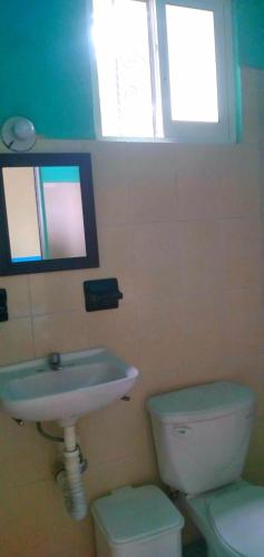 baño con lavabo y aseo y ventana en Quinta paloma, en Santa Cruz Huatulco