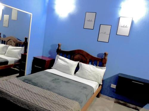 una camera da letto blu con un letto e una parete blu di Apart Belgrano a Puerto Iguazú