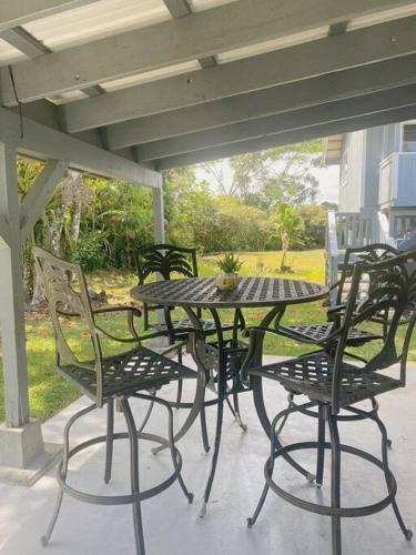 an outdoor table and chairs on a patio at Surf Getaway, Queen Bed, Private Lanai in Keaau
