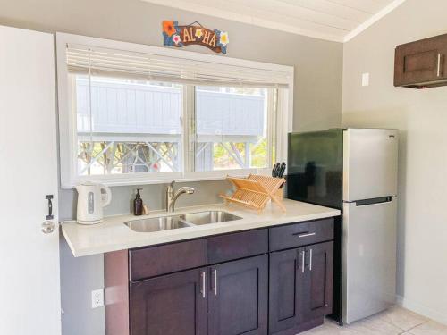 a kitchen with a sink and a refrigerator at Surf Getaway, Queen Bed, Private Lanai in Keaau