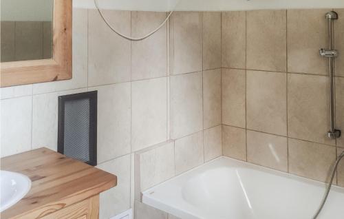 a bathroom with a bath tub and a sink at 2 Bedroom Pet Friendly Home In Popowo-letnisko 