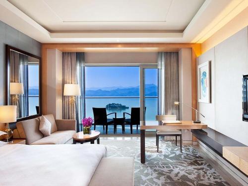 a bedroom with a bed and a living room at Sheraton Qiandao Lake Resort in Thousand Island Lake