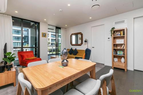 a living room with a wooden table and chairs at QV Stays Stylish Wynyard Escape in Auckland