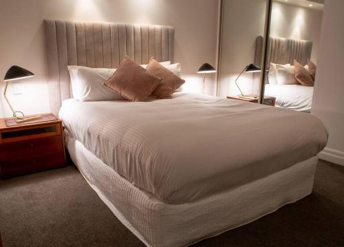 a large white bed in a bedroom with two lamps at Great Studio Apartment with Balcony Bond1009 Self- Catering in Sydney
