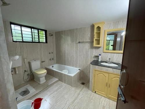 a bathroom with a tub and a toilet and a sink at Dream house in Atgaon