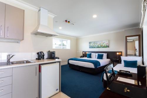 una cocina y un dormitorio con una cama en una habitación en Tuakau Hotel en Tuakau