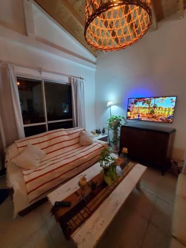 a bedroom with a large bed and a flat screen tv at Grace’s House, Ezeiza Airport in Monte Grande