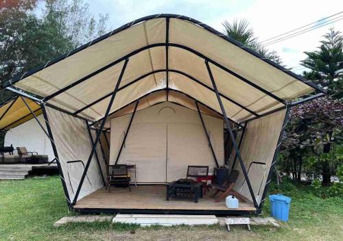 une tente avec des chaises et une table dans un champ dans l'établissement Keisaji CAMP SITE - Vacation STAY 90068v, à Ijinabaru
