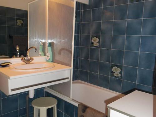 a bathroom with blue tiles and a sink and a tub at Appartement Canet-Plage, 2 pièces, 4 personnes - FR-1-750-6 in Canet-en-Roussillon